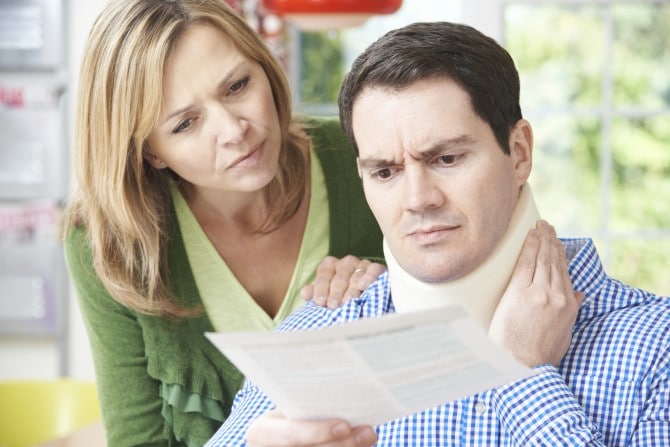 Couple Reading Letter In Respect Of Husband's Neck Injury