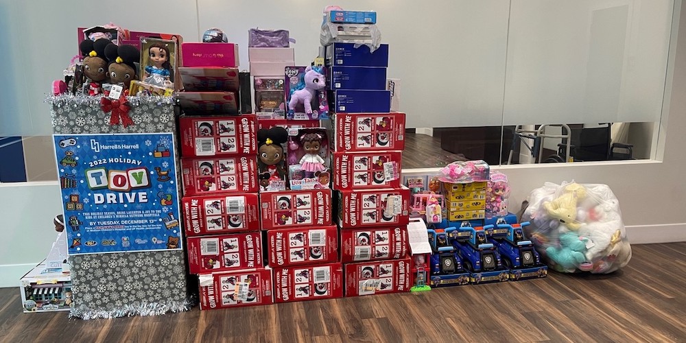 Toys and stuffed animals stacked near a donation box.