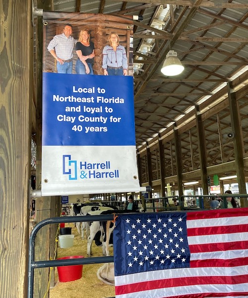 Barn banner and American flag with cows in background.