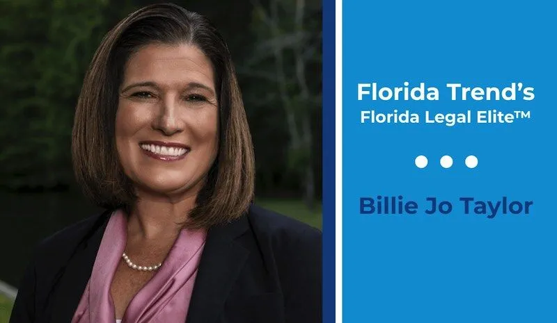 Woman with brown hair smiles in a dark blazer.