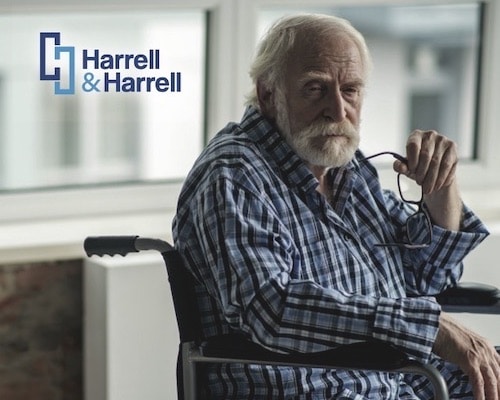 Elderly man with white beard sits in wheelchair.