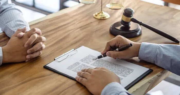 Two people discuss a document at a desk.