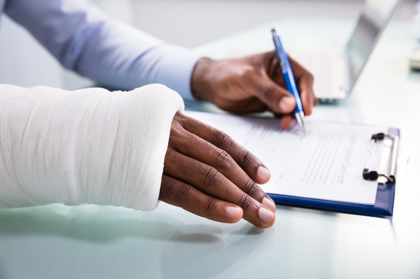Person with a bandaged arm filling out a form.