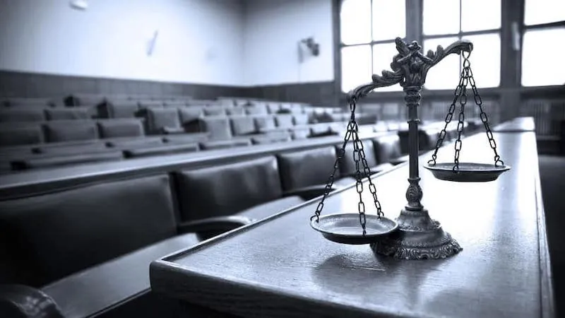 A metal balance scale rests on a desk.