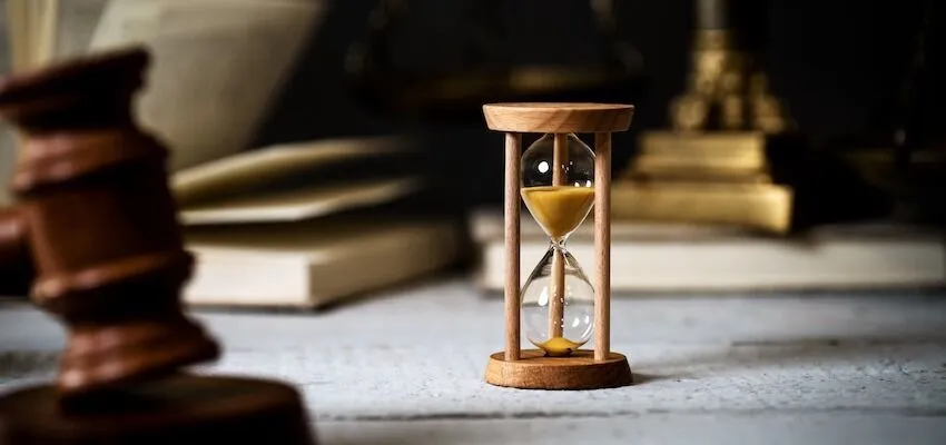 Hourglass with yellow sand sits on a table.