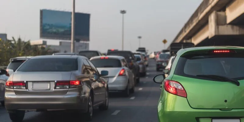 Cars sitting in traffic on a multi-lane road.