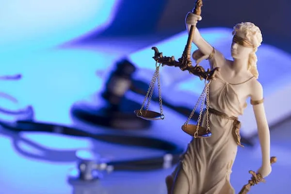 Lady Justice statue holding scales stands in focus.