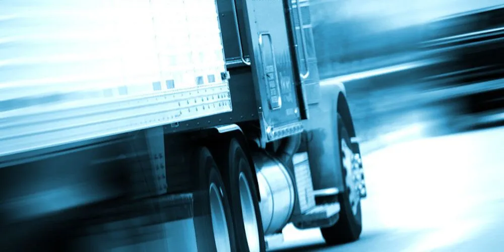 Large truck speeding down the road with motion blur.