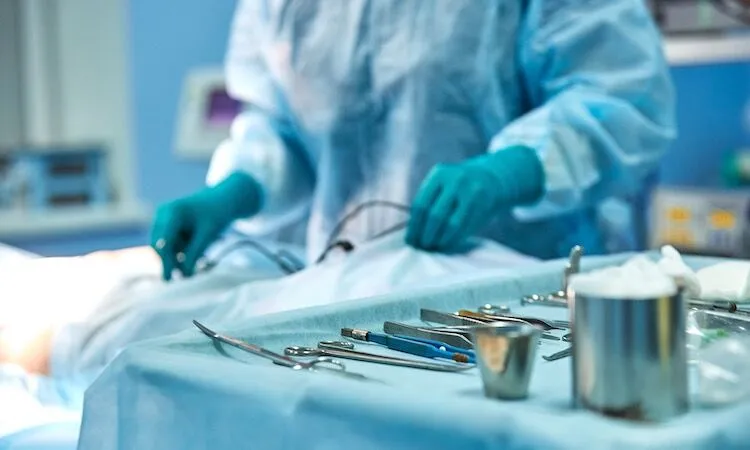Surgeon in blue scrubs prepares for surgery.