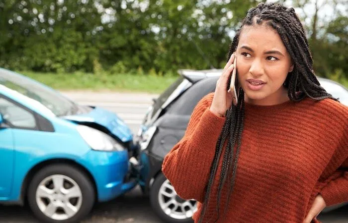 Woman in rust-colored sweater talks on her phone.