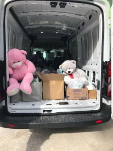 Van open at back, boxes and teddy bears inside.